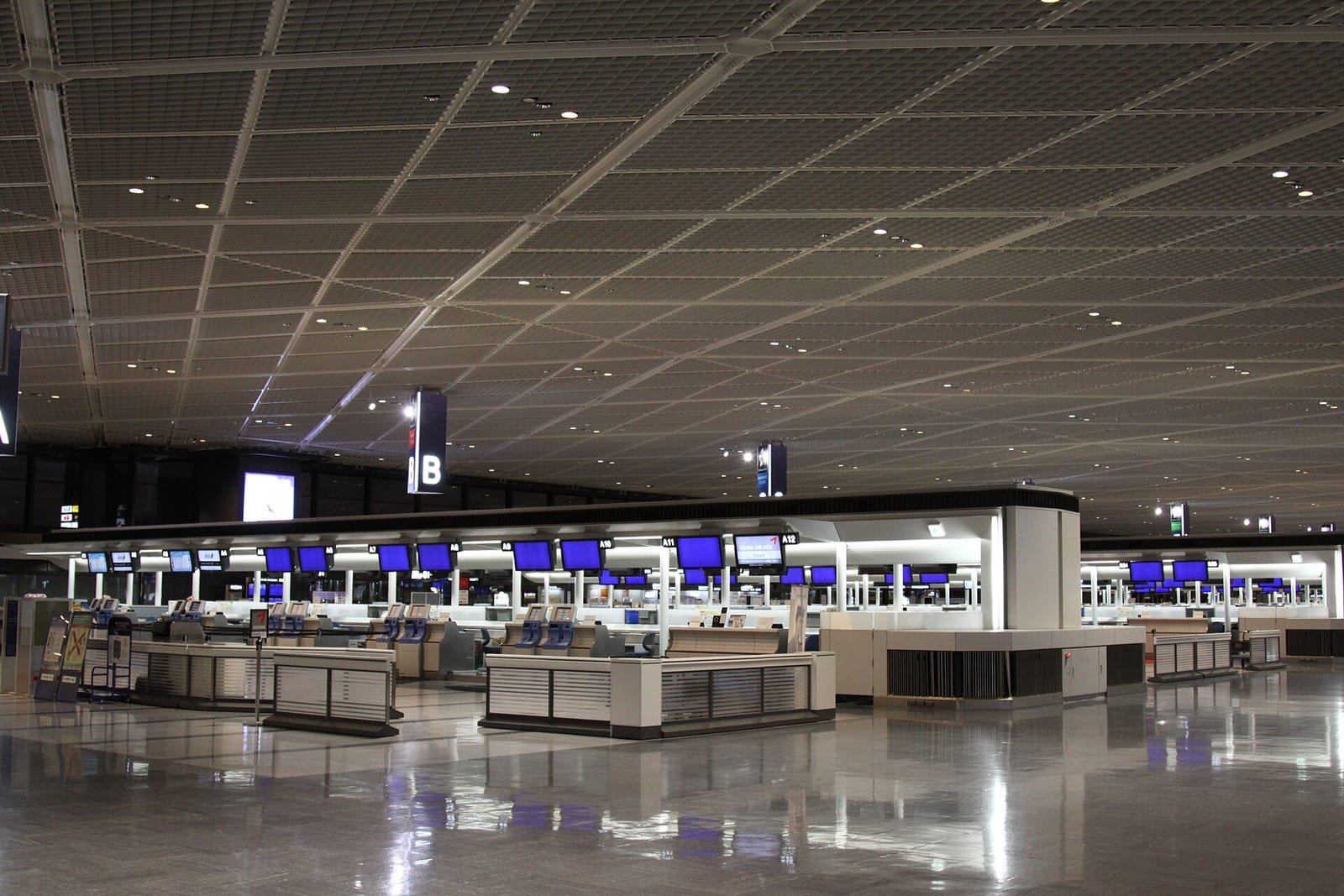 Narita Havalimanı 1. Terminal'in giriş cephesi, önünde park etmiş araçlar ve açık mavi gökyüzü altında yolcu karşılama alanı.