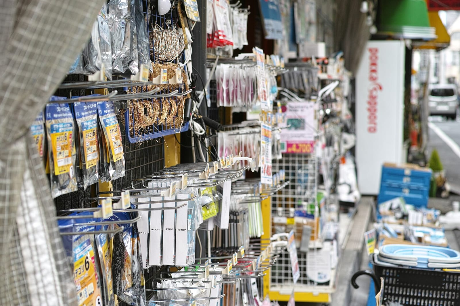 Tokyo Akihabara'da küçük bir elektronik parça dükkanının önünde, askılarda paketlenmiş çeşitli aksesuar ve parçalar sıralanmış görülüyor.