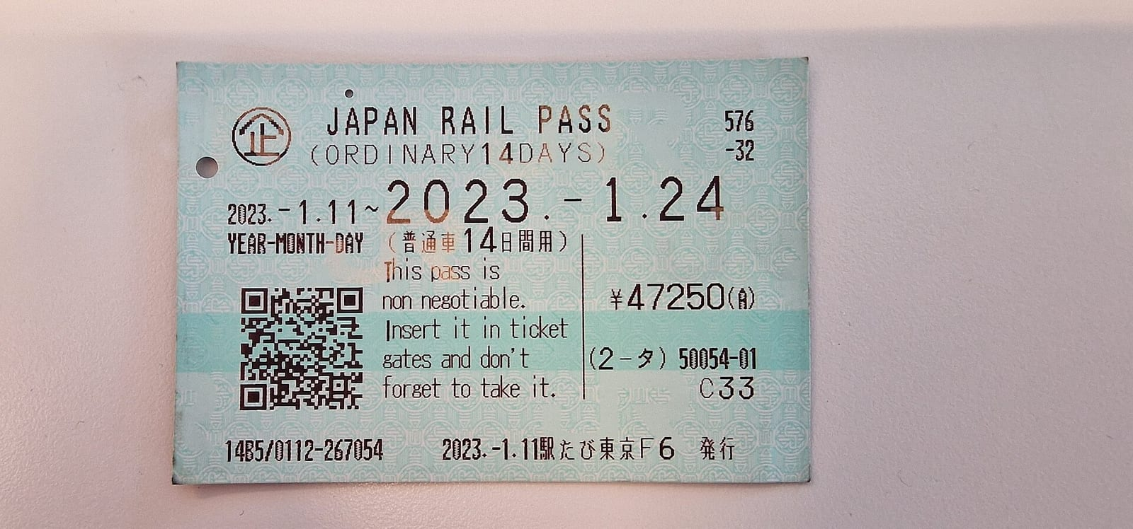 Açık gri bir zemin üzerinde, iki haftalık normal Japan Rail Pass biletinin geçerlilik tarihleri, QR kodu ve İngilizce uyarı notu görünüyor.
